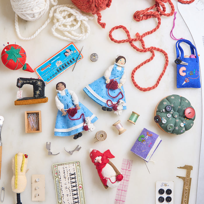 Hand-felted antique sewing machine ornament with gold embroidery and thread spool, perfect for Christmas decorating and gifting to sewists