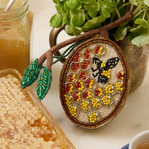 Hand-embroidered beehive ornament with beaded honeybee and shimmering honeycomb