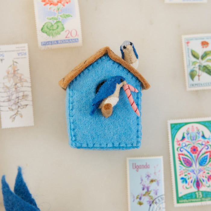 Eco-conscious felt birdhouse ornament with soft textures and natural tones, symbolizing peace, renewal, and the charm of garden life