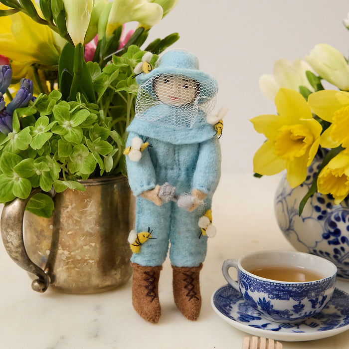 Fair trade merino-blend wool ornament of smiling woman beekeeper with warm expression