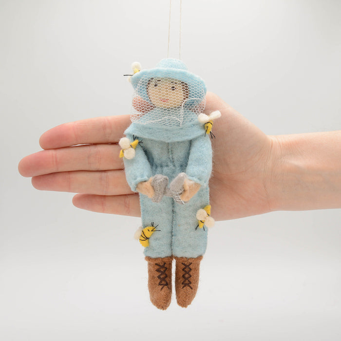 Nature-inspired ornament featuring a woman beekeeper in blue, perfect for gardeners