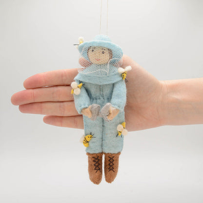 Nature-inspired ornament featuring a woman beekeeper in blue, perfect for gardeners