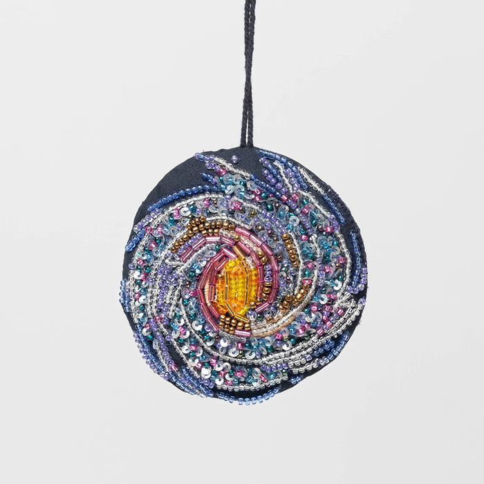 Galaxy ornament with hand-beaded Milky Way design on satin, representing stars and cosmic swirls in a spiral galaxy shape.