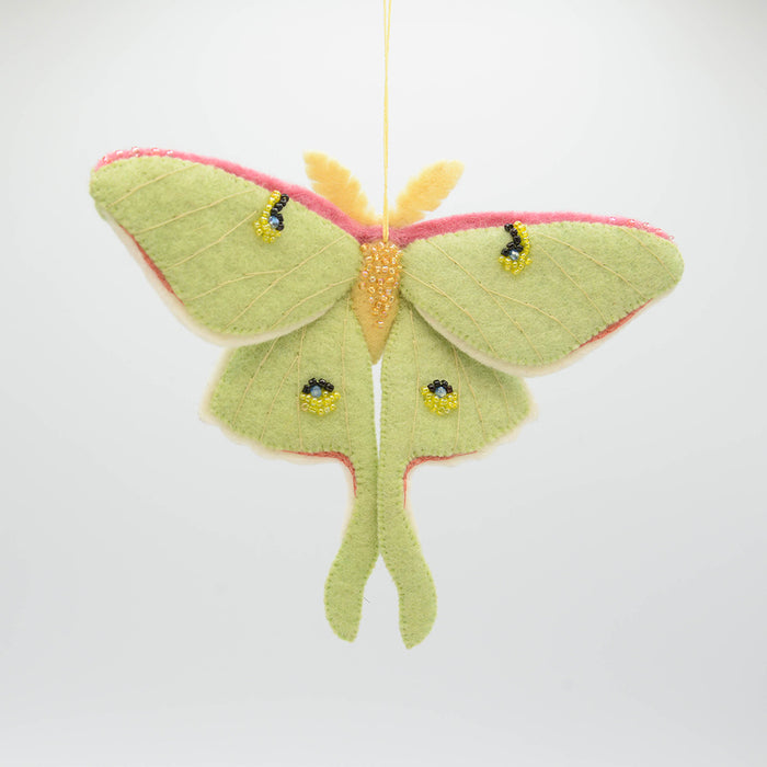 Pollinator-themed wool ornament featuring a luminous Luna Moth with fair trade craftsmanship