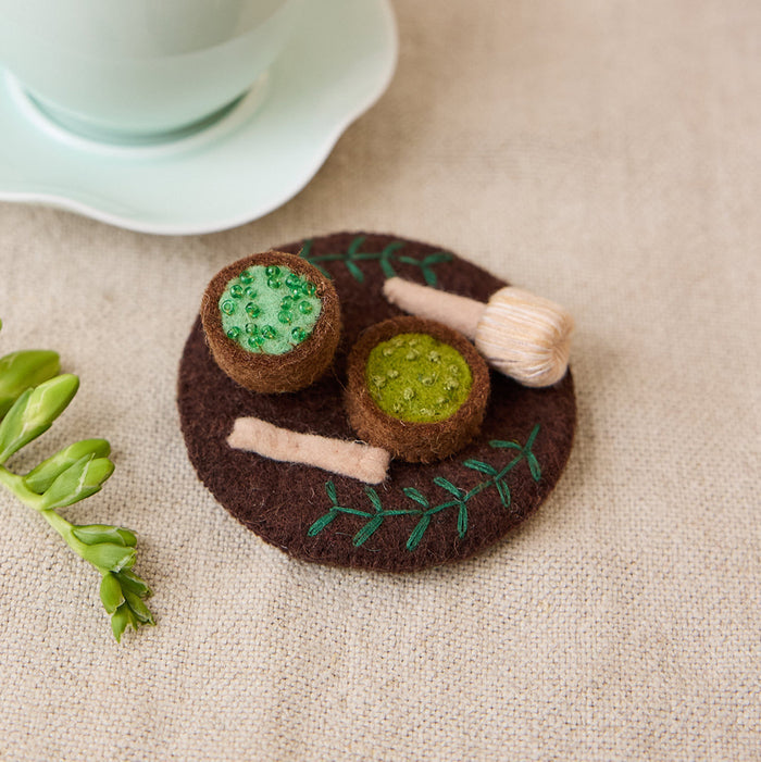 Handcrafted felt Matcha Tea Set ornament featuring matcha bowl, bamboo whisk, and embroidered green tea details, ethically made by artisans.