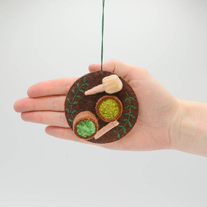 Handmade felt ornament honoring Japanese matcha tea ceremony with embroidered matcha bowl, chasen, and spoon. Ethically made and fair trade.