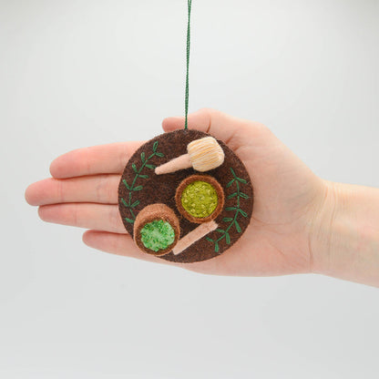 Handmade felt ornament honoring Japanese matcha tea ceremony with embroidered matcha bowl, chasen, and spoon. Ethically made and fair trade.