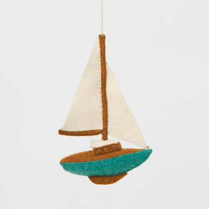 Set sail for holiday memories with our handcrafted Sailboat Ornament, a charming tribute to life on the water. Featuring crisp white sails, a warm wood-toned mast and deck, and a sea-glass-inspired turquoise hull, this classic sailboat captures the quiet beauty of coastal living and the freedom of open water.