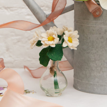 Handmade felt daisy flower bouquet with five white and yellow blooms in a recycled handblown glass vase. Eco-friendly spring décor or gift for Mother's Day, teachers, or Easter. Fair trade and sustainably crafted.