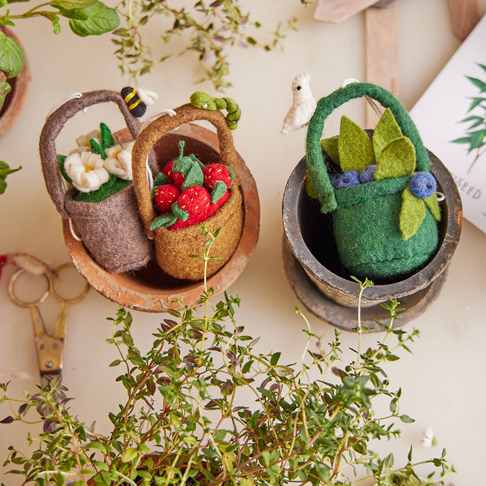 Wool felt strawberry ornament with red berries and caterpillar in handmade felt basket.
